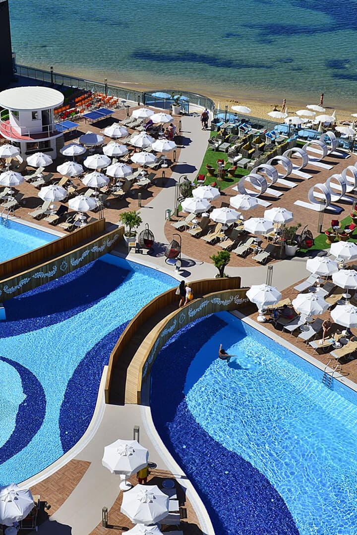 Deniz kıyısındaki Azura havuzları ve şezlonglu plaj alanı