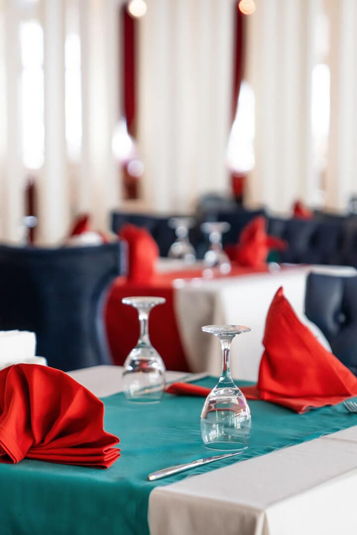 Kırmızı peçetelerle hazırlanmış Azura restoran masası